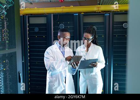 African american computer technicians using tablet working in server room Stock Photo