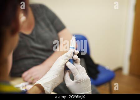 NHS & some private healthcare professionals administer vaccinations in a Surgery in the UK Stock Photo