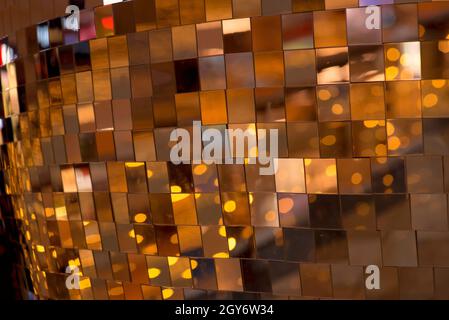Colorful square metallic tiles on a wall or floor. Blue, green, teal, yellow, orange, purple reflective tile pattern. Shiny tile pattern with purple, Stock Photo