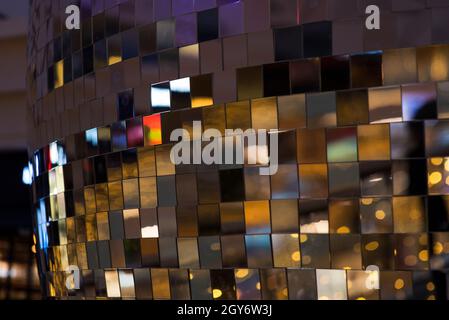 Colorful square metallic tiles on a wall or floor. Blue, green, teal, yellow, orange, purple reflective tile pattern. Shiny tile pattern with purple, Stock Photo