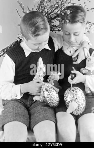 Zwei Jungen mit Ostedekoration, Deutschland 1930er Jahre. Two boys at a table with easter decoration, Germany 1930s. Stock Photo