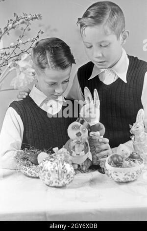 Zwei Jungen mit Ostedekoration, Deutschland 1930er Jahre. Two boys at a table with easter decoration, Germany 1930s. Stock Photo