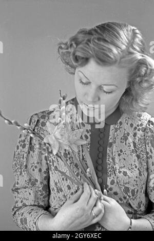 Porträt eines jungen Mädchens, Osterdekoration in den Händen haltend, Deutschland 1930er Jahre. Portrait of a young girl holding some easter decoration in her hands, Germany 1930s. Stock Photo