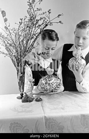 Zwei Jungen mit Ostedekoration, Deutschland 1930er Jahre. Two boys at a table with easter decoration, Germany 1930s. Stock Photo