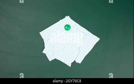 blank sheets of paper in a cage attached to a green magnetic board,  close up Stock Photo