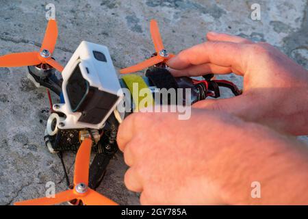 Close up of man's hands assembling FPV drone, preparing quadcopter for flight. Repair drone before training process. Stock Photo