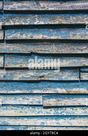 Weathered wooden shed with blue peeling paint Stock Photo