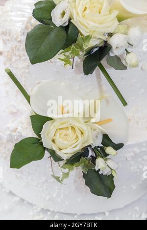 White wedding cake with real roses decoration. Stock Photo