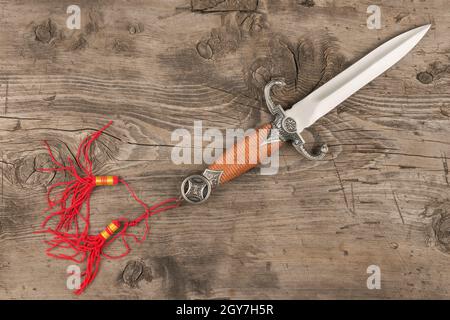 Dagger lying on a wooden surface, top view Stock Photo