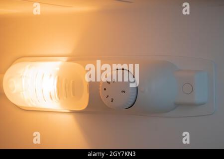 Orange light inside the refrigerator close-up. A lamp that turns on when the door is open to improve vision. Household appliances concept, changing th Stock Photo