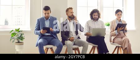 People sitting in queue in office and waiting for job interview or business appointment Stock Photo