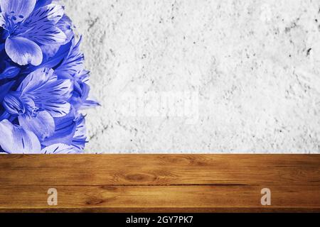 Background flowers on a textured stucco wall and blank wooden planks in the foreground. For product demonstrations, free space, layout, mockup, perspe Stock Photo