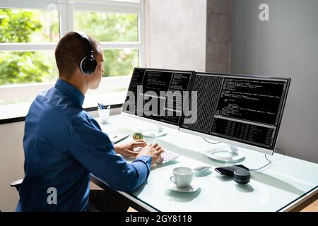 Computer Programmer Writing Program Code On Computer In Office Stock Photo