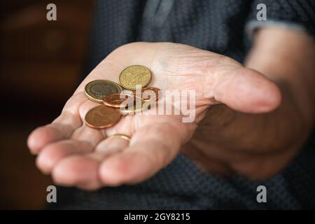 Couple of euro coins in elderly senior woman hand. Stock Photo