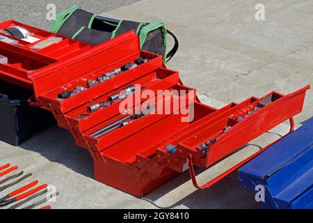 Open professional metal storage tool box on pavement Stock Photo