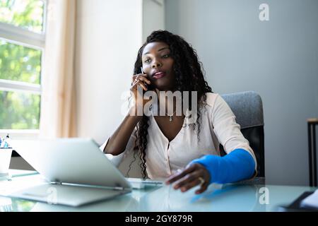 Broken Arm Injured Worker Compensation Coverage. Using Office Laptop Stock Photo
