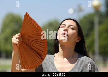 Stressed asian woman fanning suffering heatstroke in the street a warm summer day Stock Photo