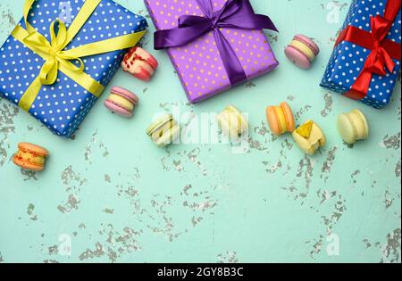 various gift boxes with tied bows and baked pasta on a green background, top view Stock Photo
