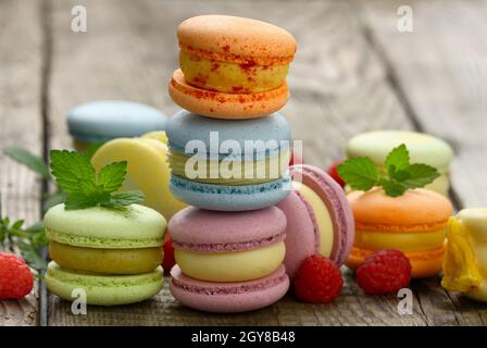 stack of baked multicolored macarons and different flavors on a gray wooden table, delicious dessert Stock Photo