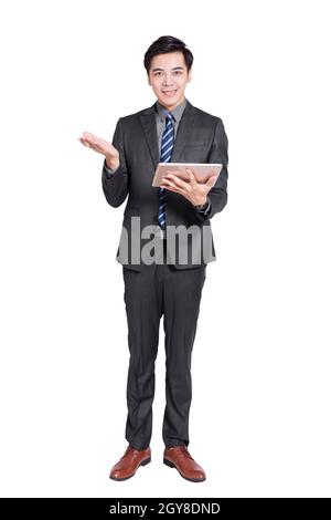 Young handsome businessman standing and holding tablet . Isolated on white background. Stock Photo