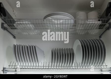 Set of different plates on the shelf in the kitchen cabinet. Kitchen utenstil concept Stock Photo