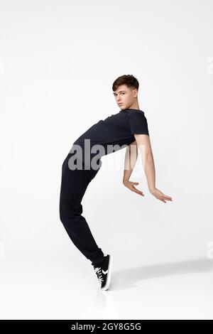 Handsome guy in black t-shirt looking into camera and jumping. Stock Photo