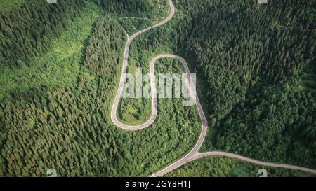 Flight over the summer mountains with mountain road serpentine, river and forest. Ukraine, Carpathian mountains. Landscape photography Stock Photo