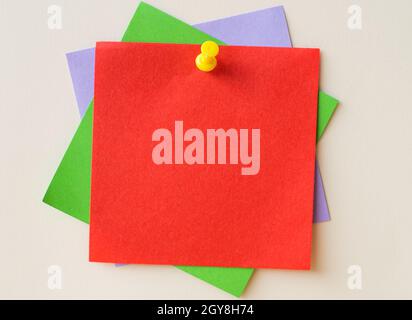 Colorful Paper Notes Stacked Together And Pinned On The Wall. Stock Photo