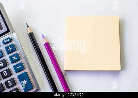 Plain Spiral Notebook With Pen Beside Calculator And Coins On Table. Stock Photo