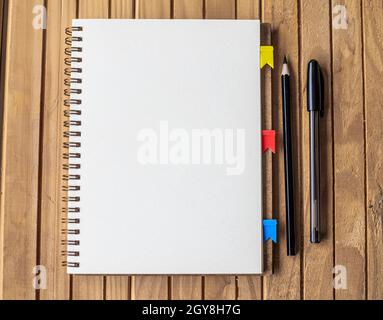Blank Open Spiral Notebook With Diffrent Pens Placed On Table. Stock Photo