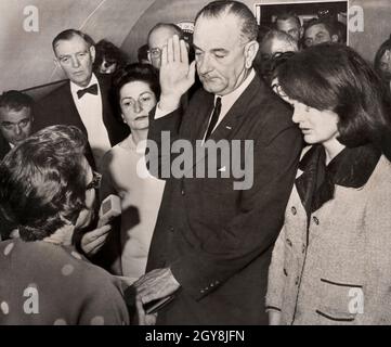 Lyndon Johnson being sworn in as U.S. President by Judge Sarah Hughes aboard Air Force One after assassination of U.S. President John F. Kennedy, First Lady Claudia 'Lady Bird' Johnson and former First Lady Jacqueline Kennedy look on, Love Field Airport, Dallas, Texas, USA, Cecil W. Stoughton, November 22, 1963 Stock Photo