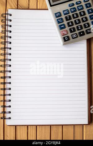 Blank Open Spiral Notebook With A Calculator Placed On Table. Stock Photo