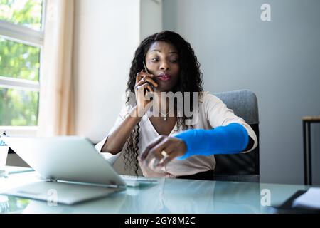 Broken Arm Injured Worker Compensation Coverage. Using Office Laptop Stock Photo