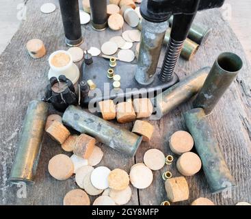 cartridge cases, wads, primers near press closeup on plank Stock Photo