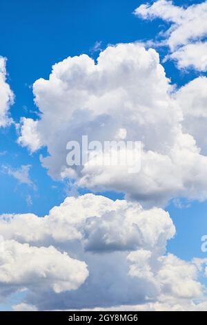 Puffy white clouds on a bright blue sky day Stock Photo