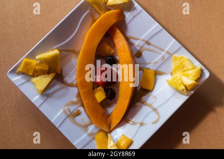 Fresh fruit slices and honey on square porcelain plate Stock Photo