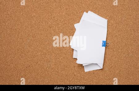 white blank paper sheets bound with a clip on brown background Stock Photo
