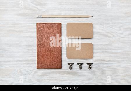 Blank branding mockup. Blank kraft business cards, notebook and pencil on light wood table background. Top view. Flat lay. Stock Photo