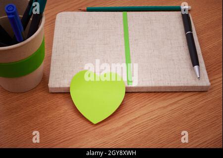 Plain Blank Open Notebooks With Stack Of Pens Container Over Table. Stock Photo