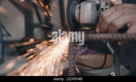 Worker man using electric wheel grinding and cutting on steel structure have spark from the grinding wheel at production industrial Stock Photo