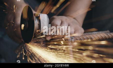 Worker man using electric wheel grinding and cutting on steel structure have spark from the grinding wheel at production industrial Stock Photo