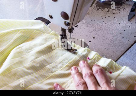 Image women's hands of seamstress working on sewing machine. Stock Photo