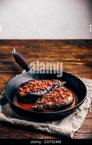 Eggplants stuffed with ground beef, tomatoes and spices in frying pan. Traditional dish Karniyarik of turkish cuisine Stock Photo