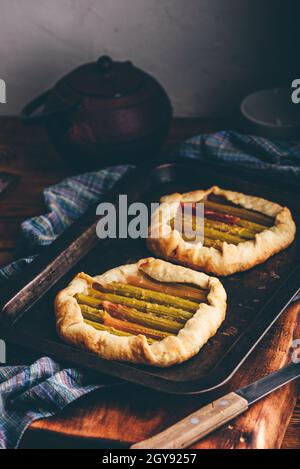 Two fresh baked rhubarb mini galettes on baking sheet Stock Photo