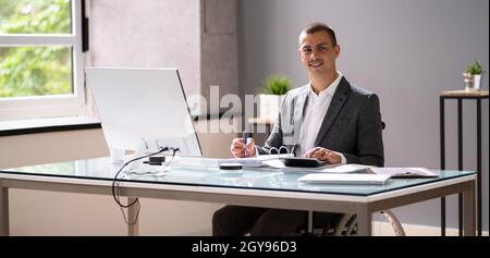 Disabled Accountant In Wheelchair Working Using Computer Stock Photo
