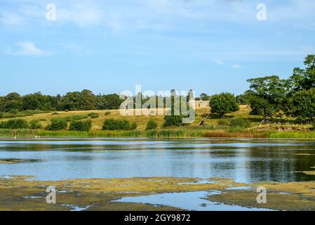 View to Felbrigg Hall in the distance over a pond, trees and fields, Norfolk, England, photographed from a public footpath. Stock Photo