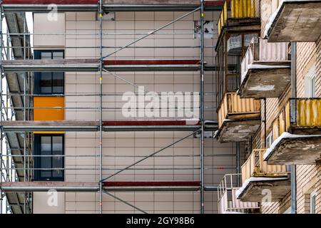 Partly renovated  old multistory building. Tall building under construction with scaffolds. Stock Photo