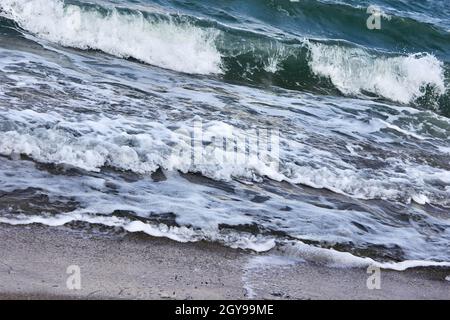 The sea in bad weather. Storm waves at sea. Dark sea, strong waves with bright white sea foam. Abstract natural sea background. Stock Photo