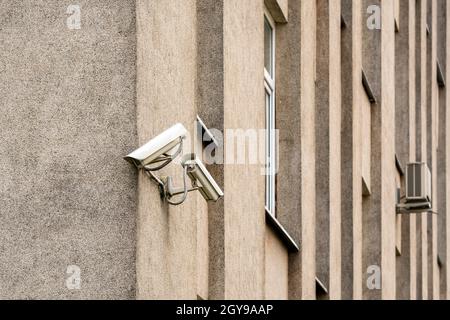Two CCTV cameras on grey building wall. CCTV security system. Stock Photo