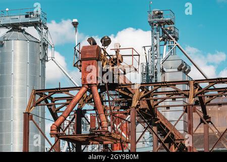 Modern granary elevator. Silver silos on agro-processing and manufacturing plant for processing drying cleaning and storage of agricultural products, Stock Photo